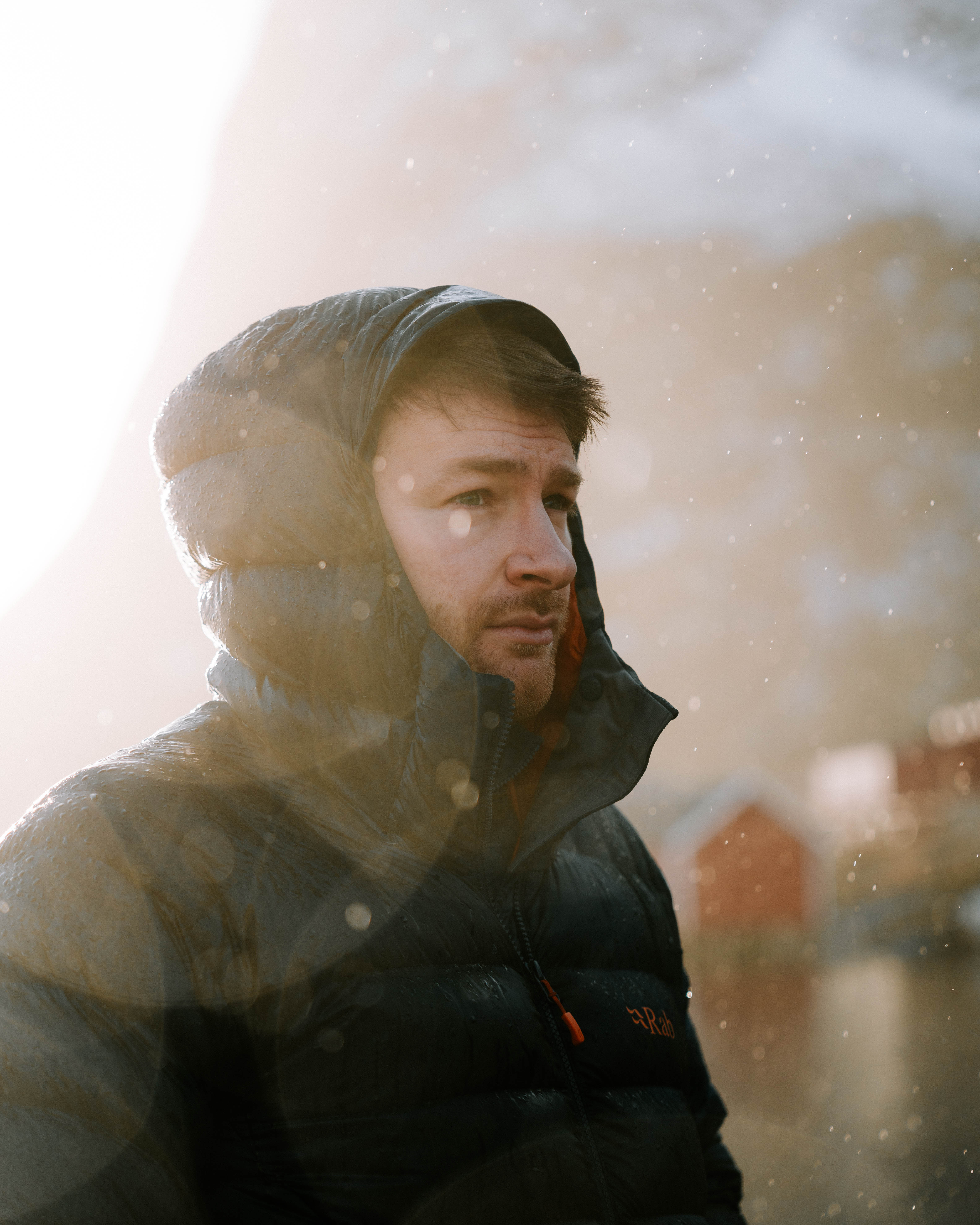 A man in a black jacket with lense flares